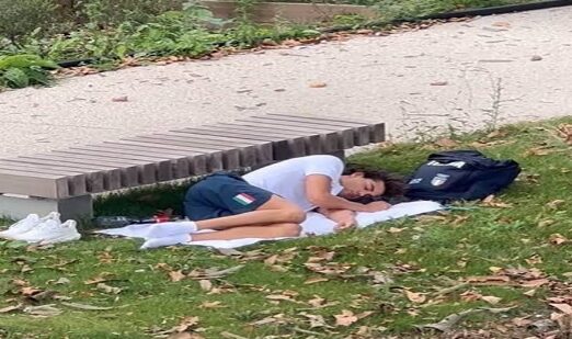 Atleta Italiano dormindo na grama sobre uma toalha devido ao calor que fazia dentro da vila olímpica.